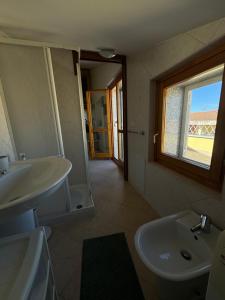 a bathroom with a sink and a toilet and a window at PM 6 Via Giovanni Giolitti Guest House in Alghero