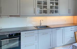 a kitchen with white cabinets and a sink at Stunning Apartment In Eidsvåg I Romsdal in Toven +6 photos