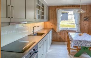 een keuken met witte kasten en een tafel en een raam bij Beautiful Apartment In Eidsvg I Romsdal With Wifi 