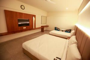 a hotel room with two beds and a flat screen tv at HOTEL SHUBHAM PALACE in Hyderabad