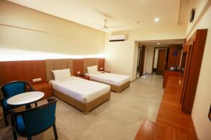 ein Hotelzimmer mit 2 Betten und einem Tisch in der Unterkunft HOTEL SHUBHAM PALACE in Hyderabad