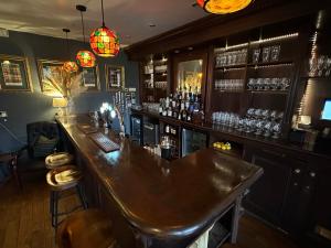 a bar with a wooden counter in a room at Burford Lodge Hotel - Adults only in Burford