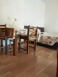 ein Esszimmer mit einem Tisch, Stühlen und einem Bett in der Unterkunft Bellini Apartment's in Novara