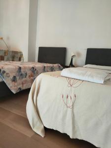 ノヴァーラにあるBellini Apartment'sのベッドルーム1室(ベッド2台、白い毛布付)