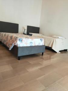 ein Schlafzimmer mit einem Bett und einem Tisch auf einem Holzboden in der Unterkunft Bellini Apartment's in Novara