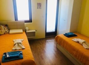 two beds in a small room with towels on them at Сънрайз Данаилов in Obzor