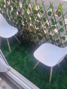 two white chairs sitting next to a plant at Stylish villa homes in Mombasa