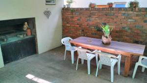 a wooden table and chairs in front of a brick wall at Anri Guesthouse in Bloemfontein
