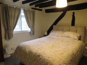 a bedroom with a bed and a window at River Cottage in Tewkesbury