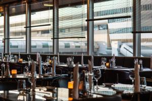 a restaurant with tables and chairs with a train in the background at Frankfurt Airport Marriott Hotel in Frankfurt