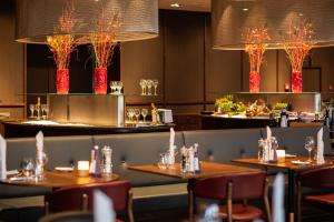 um restaurante com mesas, cadeiras e luzes em Frankfurt Airport Marriott Hotel em Frankfurt