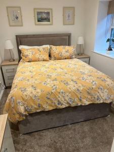 a bedroom with a bed with a yellow comforter and pillows at Brewers Den a Beautiful 1-Bed Apartment in Masham in Ripon
