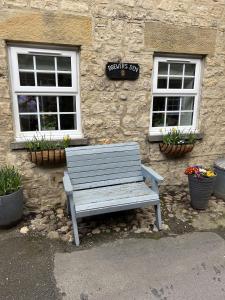 a wooden bench sitting in front of a stone building at Brewers Den a Beautiful 1-Bed Apartment in Masham in Ripon