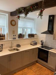 a kitchen with a sink and a stove top oven at Brewers Den a Beautiful 1-Bed Apartment in Masham in Ripon