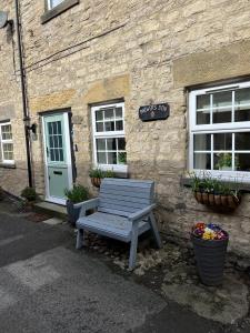 a wooden bench sitting outside of a stone building at Brewers Den a Beautiful 1-Bed Apartment in Masham in Ripon