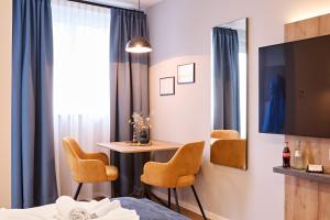 a hotel room with a bed and a table and chairs at XZLLENZ - Modern, Neu, Luxus, Frei-Parken, U-Bahn in Nuremberg