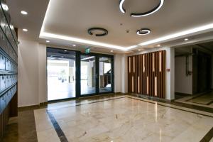 een lobby met een grote glazen deur en een tegelvloer bij PAONI Apartment by Solid Residence Butoaie Mamaia in Mamaia