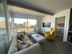 ein Wohnzimmer mit einem Sofa und einem gelben Stuhl in der Unterkunft Apartamento en urbanización con fantásticas vistas in Benalmádena