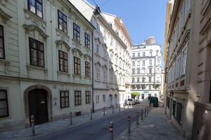 an empty street in a city with tall buildings at Designer apartment - centrally located in Vienna