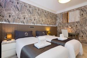 - 2 lits dans une chambre d'hôtel ornée d'une fresque murale dans l'établissement Villa Nakalua, à Luxembourg