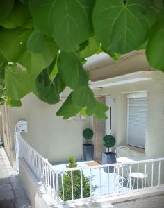 a balcony with potted plants and a white railing at DION'S HOME with Private Parking at the Center of Kos Town in Kos