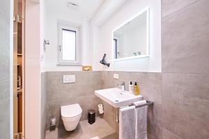 a bathroom with a sink and a toilet and a mirror at XZLLENZ - Modern, Neu, Luxus, Frei-Parken, U-Bahn in Nuremberg