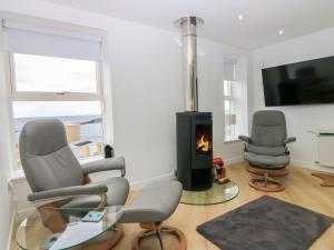 a living room with two chairs and a fireplace at Craignure in Banff