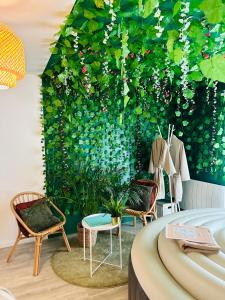 a room with chairs and a green wall with plants at Chez Jade - Spa, Gare et centre ville in Rennes