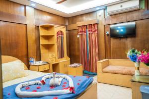 ein Schlafzimmer mit einem Bett und einem TV in einem Zimmer in der Unterkunft Lemon Garden Resort & Spa in Sreemangal
