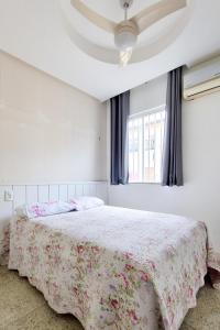 a bedroom with a bed with a floral bedspread and a window at Apartamento completo COP30 Belém in Belém