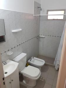 a white bathroom with a toilet and a sink at Casa en La Punta - San Luis in La Punta