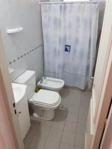 a bathroom with a toilet and a shower curtain at Casa en La Punta - San Luis in La Punta