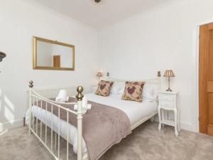 um quarto com uma cama branca e um espelho em Pass the Keys Central 3 bedroom house with parking em Bath
