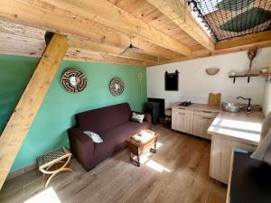 een woonkamer met een bank en een keuken bij Cabane en forêt la mechta in Bologne