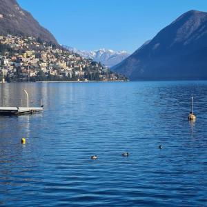 a view of a lake with a town and mountains at Town Center Lugano in Lugano