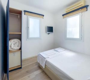 een kleine slaapkamer met een bed en een raam bij Körfez Pansiyon in Bodrum City