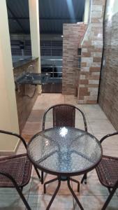 a glass table and chairs on a patio at Um lugar calmo e aconchegante in Manaus