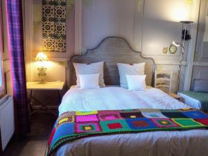 ein Schlafzimmer mit einem Bett mit einer bunten Decke darauf in der Unterkunft Envie de Sud in Vauvert
