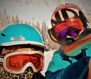 una persona con gli occhiali protettivi e un casco su uno snowboard di Thurners urige Frühstücks Pension a Würmlach