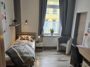 um quarto com uma cama, uma janela e uma cadeira em Familienfreundliche FeWo für 6 Personen em Bremerhaven