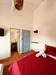 巴里查拉的住宿－Casa Quintanilla Barichara，一间卧室配有红色的床和红色毯子