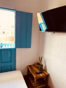 een slaapkamer met een bed en een tafel met een tv bij Casa Quintanilla Barichara in Barichara
