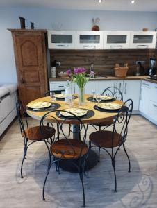 una cucina con tavolo, sedie e fiori di les Seilles de Clovis a Entremont-le-Vieux