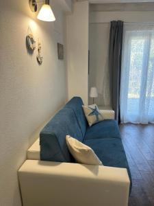 Sofá azul en la sala de estar con ventana en Nei castagni en Levanto