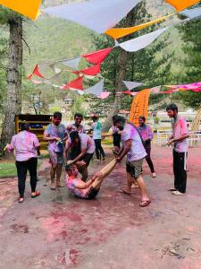 a group of people playing in the mud at Himtrek Riverside Camps, Kasol in Kasol