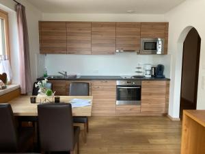 Sedlhof Apartment في Grub: مطبخ بدولاب خشبي وطاولة خشبية