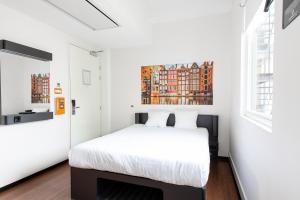 a bedroom with a bed and a painting on the wall at easyHotel Amsterdam City Centre South in Amsterdam +62 photos