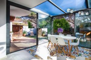 einen Wintergarten mit einem weißen Tisch und Stühlen in der Unterkunft CABOT in Sant Andreu de Llavaneres