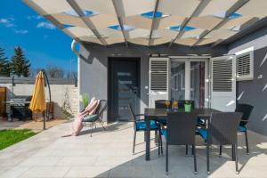 una persona seduta su un patio con tavolo e sedie di Casa Astra by Briskva a Marčana