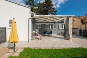un patio con ombrellone e una casa di Casa Astra by Briskva a Marčana